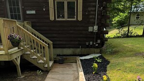 A wooden deck leading to a house with a sign reading "Lakehouse".