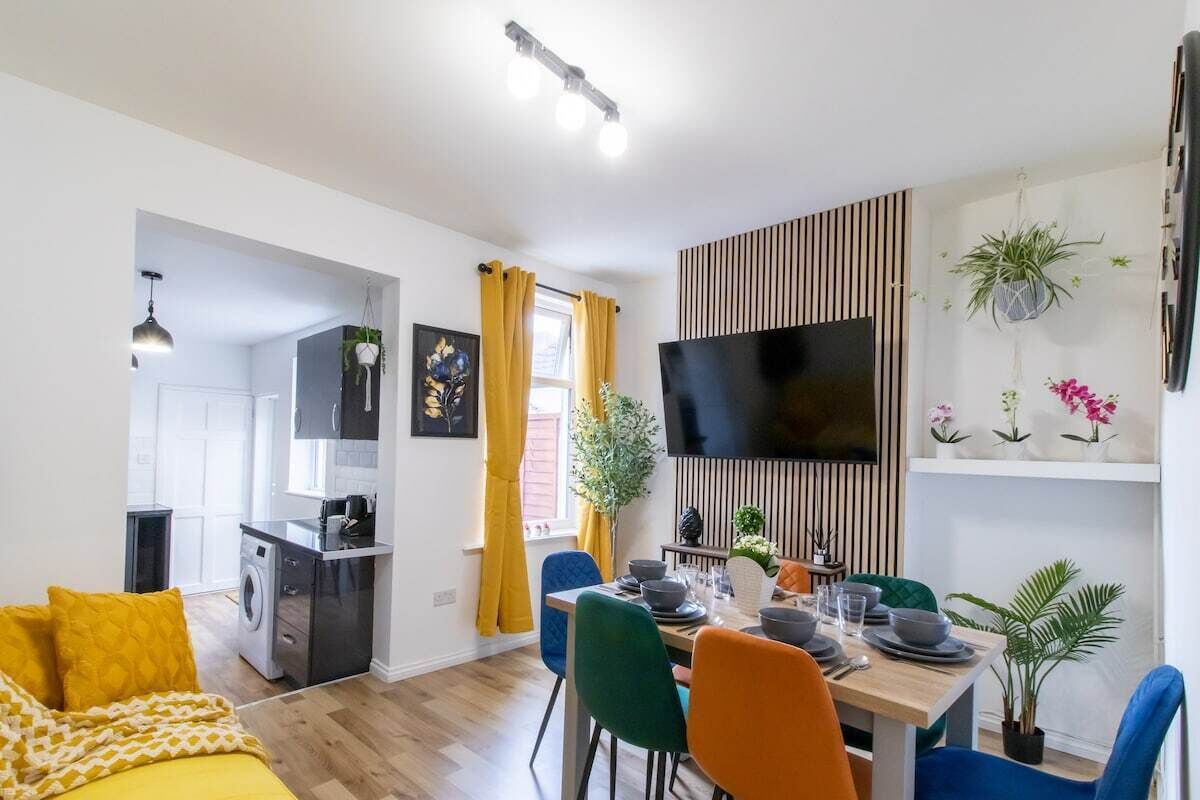 A modern apartment with a dining area, kitchen, and living room.