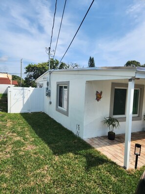 A small, single-story house with a white exterior and a covered porch area. - Boca Jewels with Heated Jacuzzi (Boca Raton)
