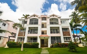 A multi-story hotel with a central entrance, balconies, and a well-maintained garden. - Magic Cortesea luxury beach (Punta Cana)