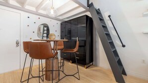 A modern interior with a dining area, a staircase, and a black wardrobe. - Vibrant Central Telluride Studio w Hot Tub (Telluride)