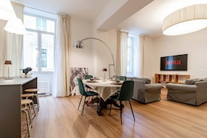A modern living room with a dining area, a sofa set, a flat-screen TV, and a coffee table. - THE QUEEN'S APARTMENT - Ariston - Centro (Sanremo)