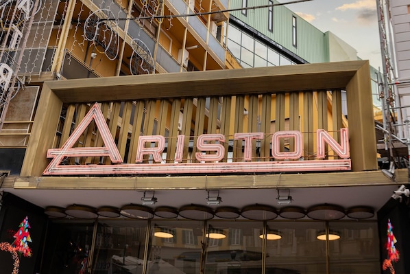 A building with a neon sign spelling 'ARISTON' on the facade.
