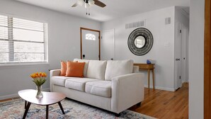 A living room with a white sofa, a round coffee table, and a patterned rug. - WELCOME TO THE OWL'S NEST - 2 BEDROOM HOME IN AUGUSTA, WINERIES & THE KATY TRAIL (Augusta)