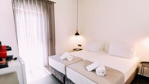 Een hotelkamer met twee bedden, een bureau met een rode apparatuur en een hanglamp.