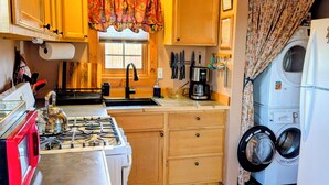 A compact kitchen with a gas stove, sink, and a coffee maker. - Bluff Bungalow w/ Patio, Dogs Welcome (Bluff)