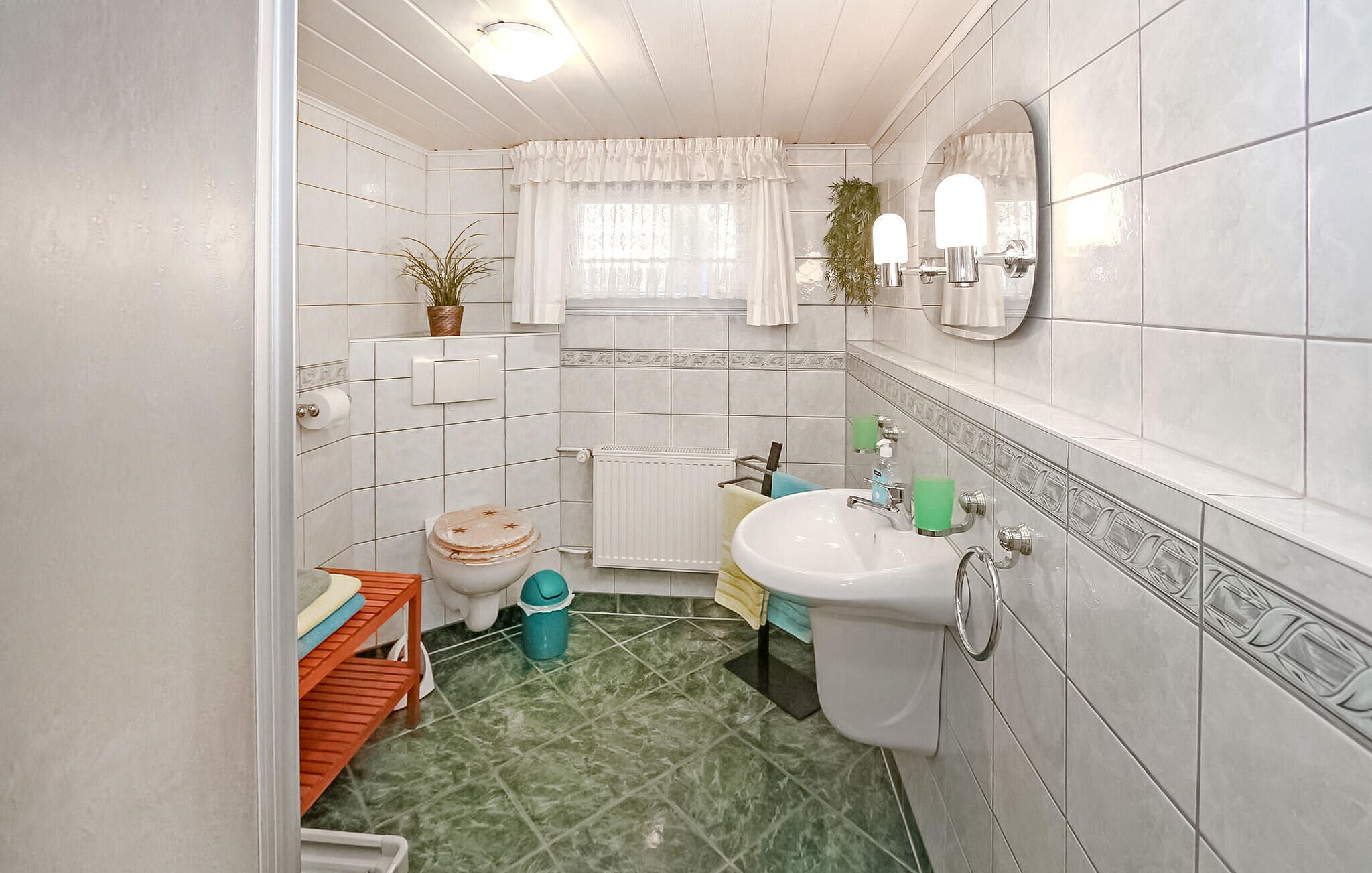 A compact bathroom with a toilet, sink, and shower area.