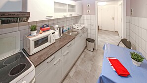 Una cocina moderna con estufa, microondas, pileta y un comedor con mesa y sillas.