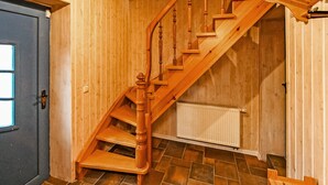 A wooden staircase with a handrail, leading to an upper floor.