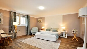 A hotel room with a bed, a chair, a desk, a lamp, a picture on the wall, and a window with curtains. - Stunning home in Tabre (Tabre)
