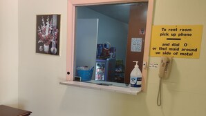 A room with a mirror, a framed picture, a phone, and a vending machine. - Rolling Fork Motel (Rolling Fork)