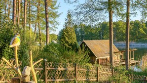 A rustic cabin by a lake surrounded by dense forest. - Ferienhaus Rheinsberg OT Kagar (Rheinsberg OT Kagar)