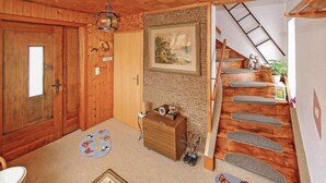 A wooden interior with a wooden staircase, a welcome mat, a small wooden chest, and a painting on the wall. - Ferienwohnung Neukloster (Neukloster)