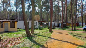A campground with RVs and mobile homes, surrounded by trees. - Ferienhaus Ueckermünde Bellin (Ueckermünde OT Bellin)