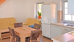 Una cucina compatta con angolo ristoro, frigorifero e una finestra con una pianta.