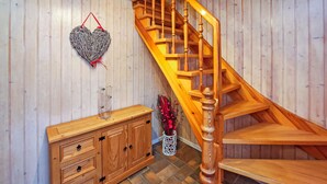 Una escalera de madera con barandilla de madera y una decoración con forma de corazón en la pared.