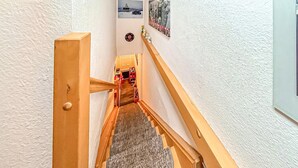 En smal trappe med trægelændere og et tæppe.