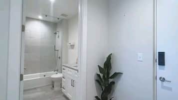 Een moderne badkamer met een bad, toilet en wastafel.