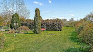 A well-maintained garden with a variety of trees and a lawn. - Ferienwohnung Hohen Sprenz (Hohen Sprenz)