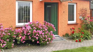 A house with a green door, two windows, and a brick pathway leading to the entrance. - Ferienwohnung Hohen Sprenz (Hohen Sprenz)