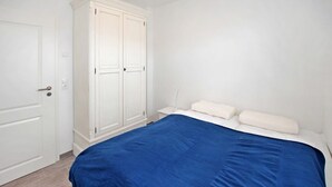 A bedroom with a bed, a wardrobe, and a nightstand. - 1 bedroom awesome apartment in Userin (Userin)