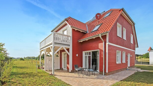 A red house with a covered porch and a small patio area. - 1 bedroom awesome apartment in Userin (Userin)