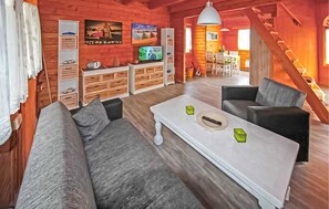 L’intérieur d’un chalet confortable, avec un canapé, une table basse et un téléviseur.