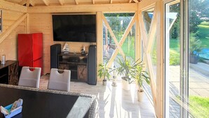 A cozy wooden interior with a TV, seating area, and potted plants. - Ferienwohnung Neppermin/Usedom (Neppermin/Usedom)