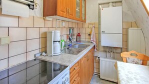 Uma cozinha compacta com fogão, pia e geladeira.