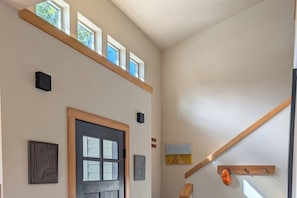 Un couloir avec une porte à deux battants, une poutre en bois et une petite fenêtre.