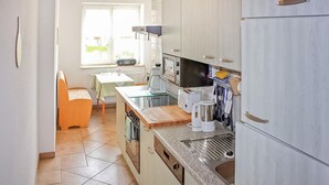 Une cuisine compacte avec un coin repas, une fenêtre et une vue sur l’extérieur.