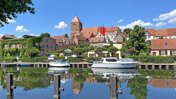 A canal with boats, a church, and traditional buildings. - Ferienhaus Plau am See (Plau am See)