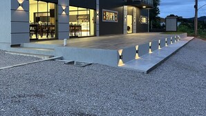 Un bâtiment moderne à deux étages, doté d’un toit plat, de grandes fenêtres et d’un balcon.