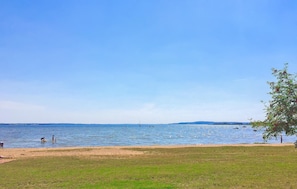 A beach with a clear sky, calm water, and a grassy area. - Stunning home in Verchen with WiFi (Verchen)