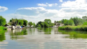 A calm river with boats and a dock, surrounded by greenery and trees. - Nice ship in Verchen with kitchen (Verchen)