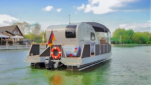 A stationary boat with a cabin, a flag, and a life preserver. - Nice ship in Verchen with kitchen (Verchen)