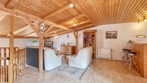 Hyggelig træindretning med siddeområde, bogreoler og en bar.