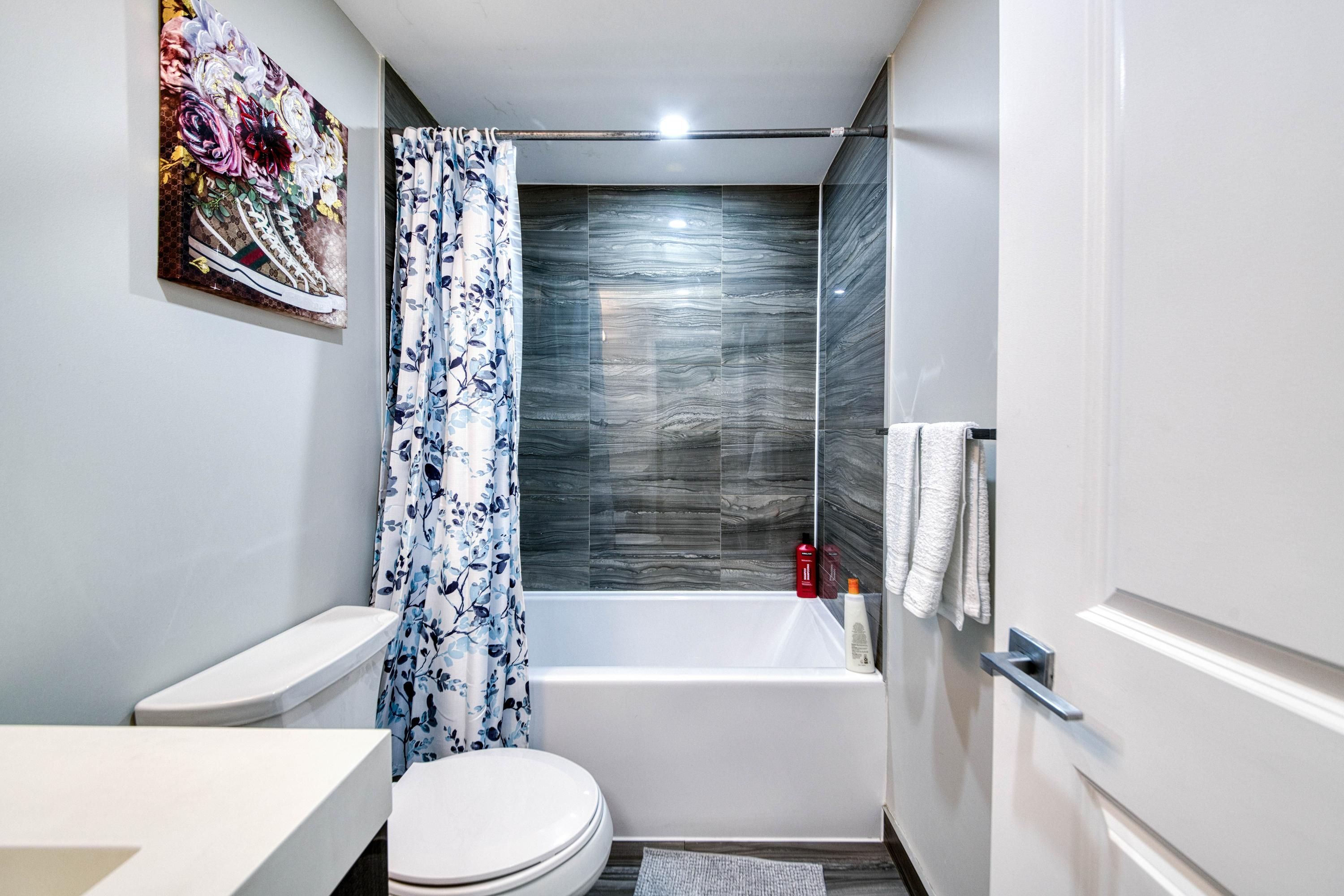 A modern bathroom with a toilet, sink, and bathtub.