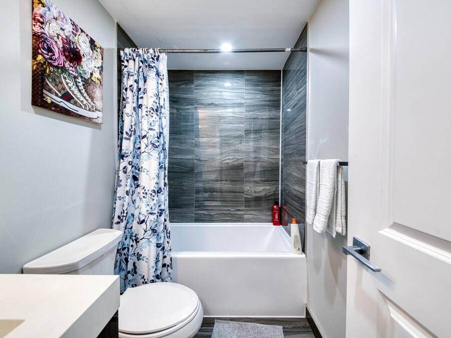 A modern bathroom with a toilet, sink, and bathtub.