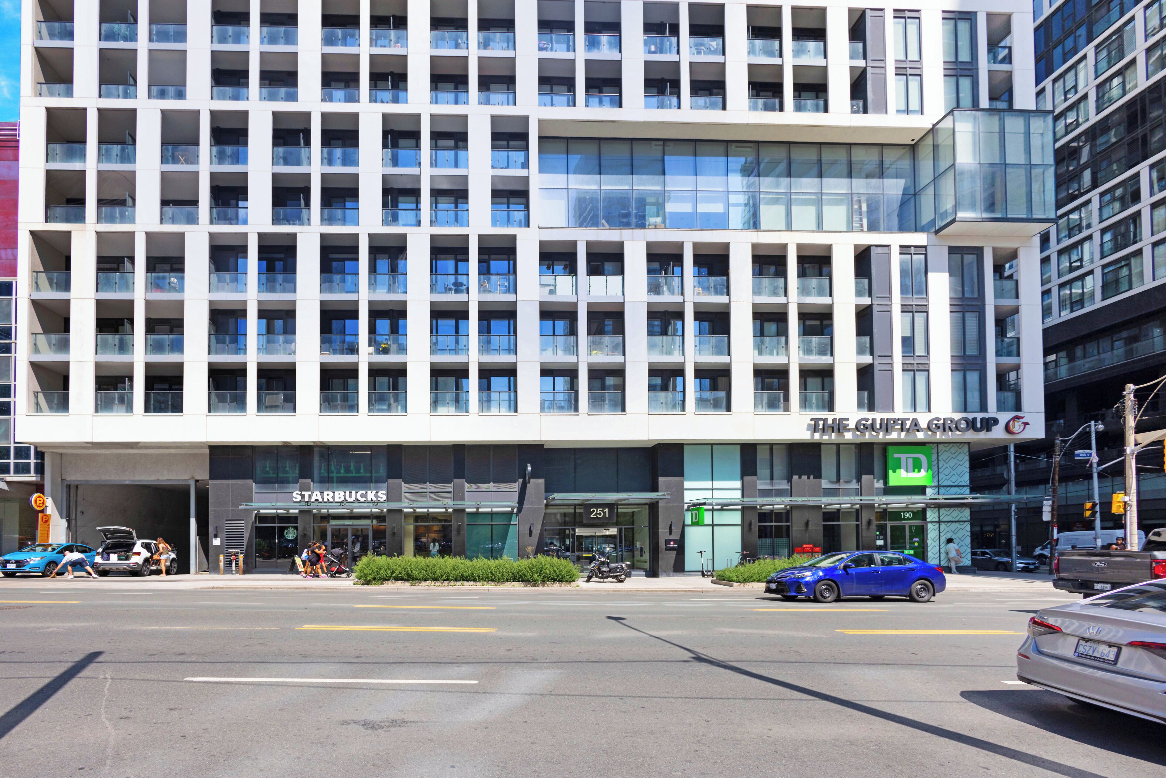 Een modern gebouw met meerdere verdiepingen, een Starbucks en een TD Bank filiaal.