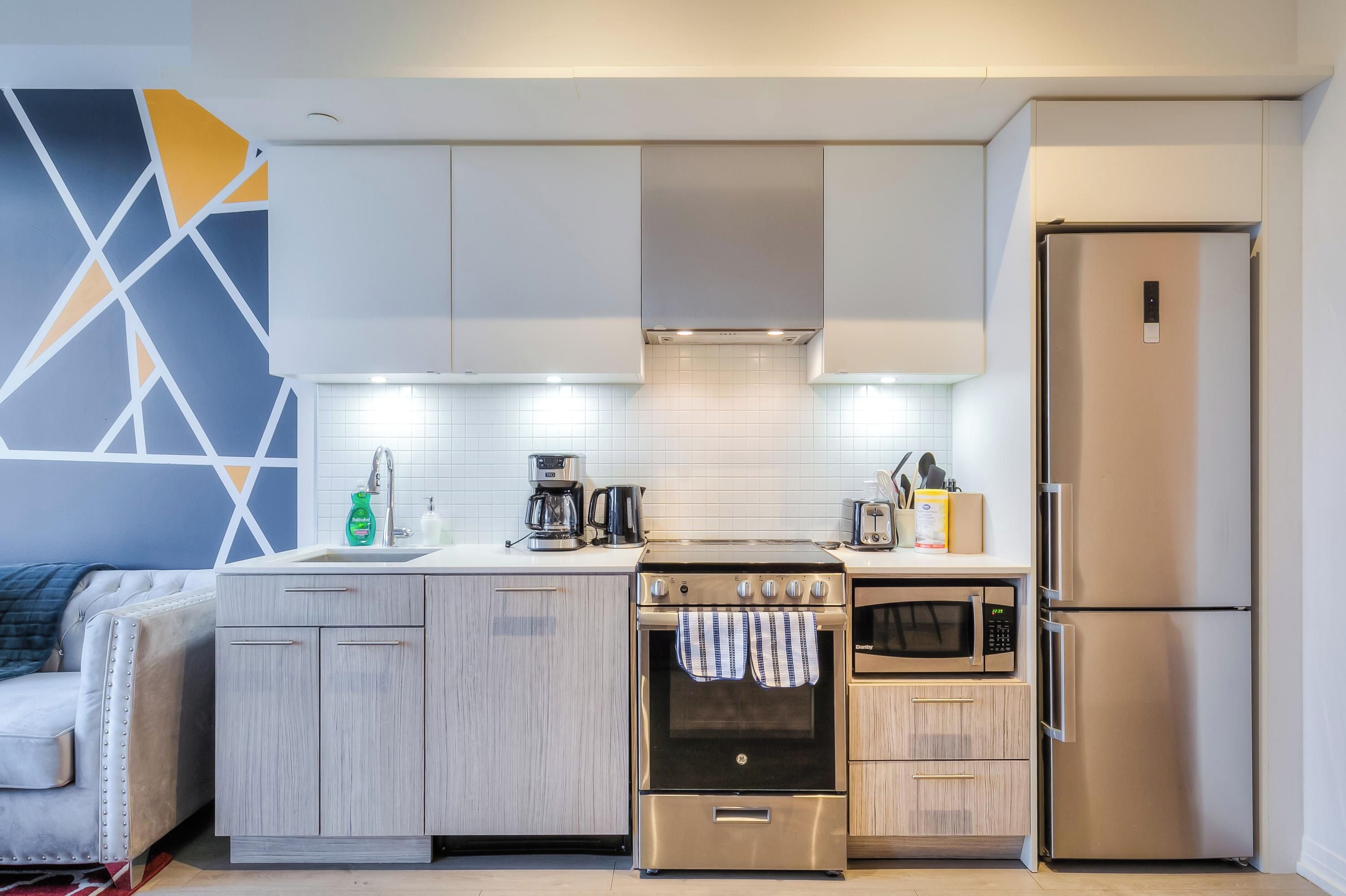 A modern kitchen with a built-in oven, microwave, and refrigerator.