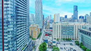A high-rise urban area with modern buildings, a parking lot, and a clear sky. - Panorama Suites (Toronto)