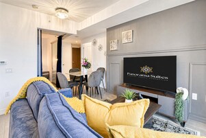 Una sala de estar moderna con un sofá, una mesa de centro y un televisor de pantalla plana montado en la pared.