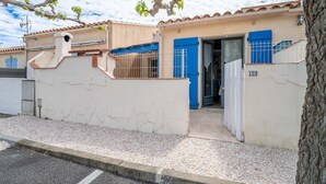 A building with a beige facade, a blue door, and a numbered sign. - Holiday Home 'Fleurynes' with Terrace and Private Garden (Fleury)