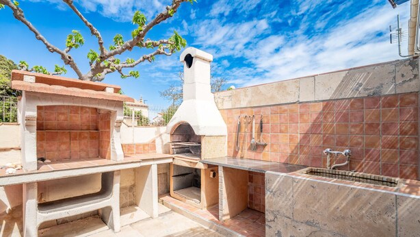 An outdoor kitchen area with a pizza oven, a sink, and a tiled backsplash. - Holiday Home 'Fleurynes' with Terrace and Private Garden (Fleury)