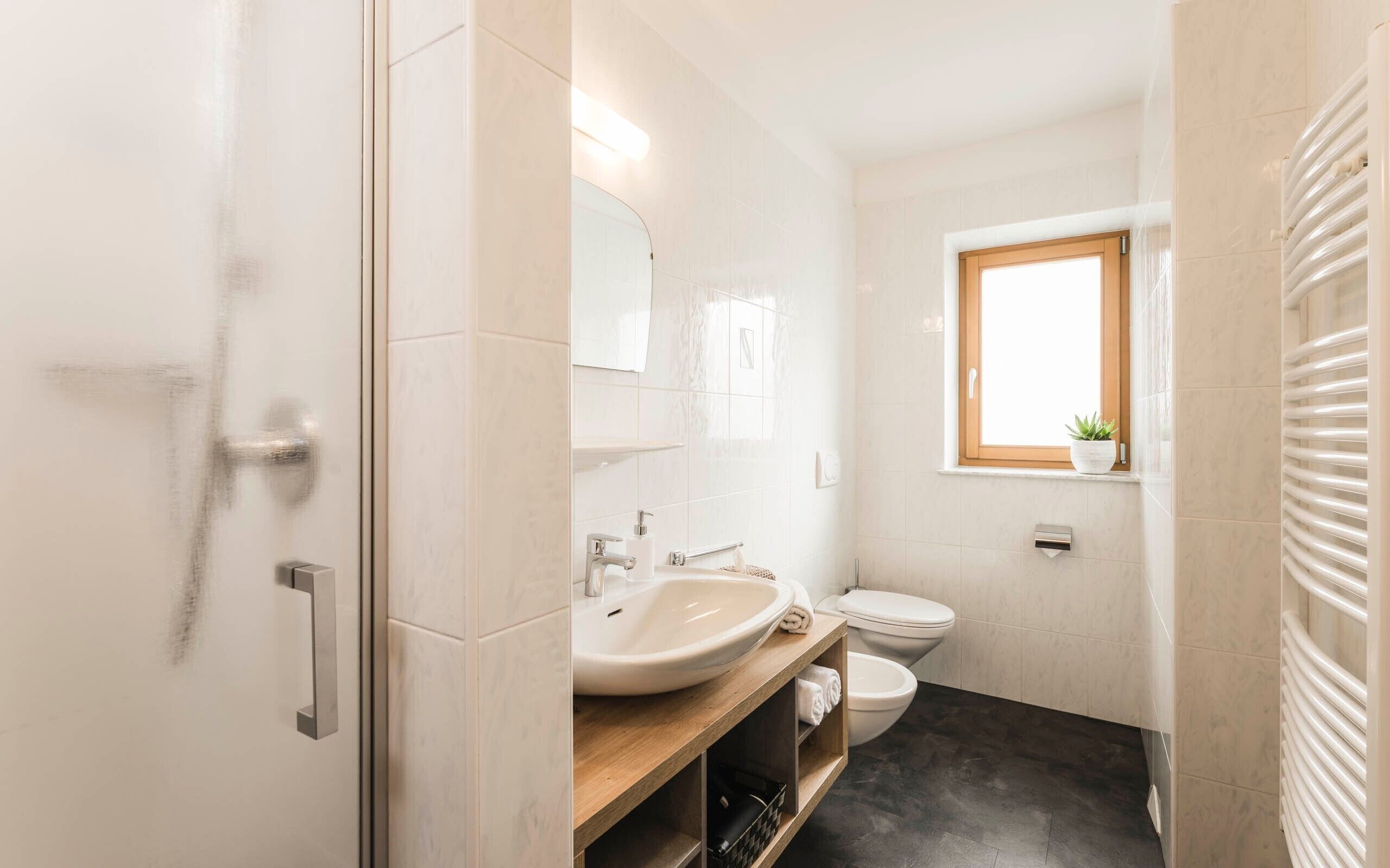 Un baño con lavabo, inodoro y ventana.