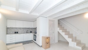 Eine moderne Küche mit weißen Schränken, einem eingebauten Ofen und einer Holzkiste.