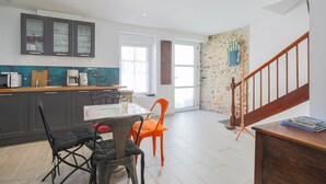 Une cuisine moderne avec un coin repas, un escalier et une vue sur l’extérieur.
