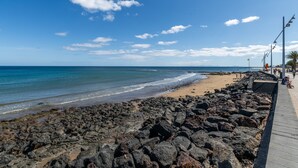 A rocky beach with a wooden walkway, ocean view, and clear sky. -  'Alma Ocean View' with Sea View, Shared Pool and Wi-Fi (Puerto del Carmen)