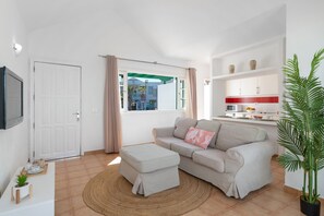 A living room with a sofa, ottoman, and a television. -  'Alma Ocean View' with Sea View, Shared Pool and Wi-Fi (Puerto del Carmen)